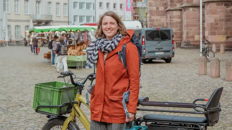 Eva Jerger von der Erzdiözese mit ihrem Lastenrad vor dem Freiburger Münster