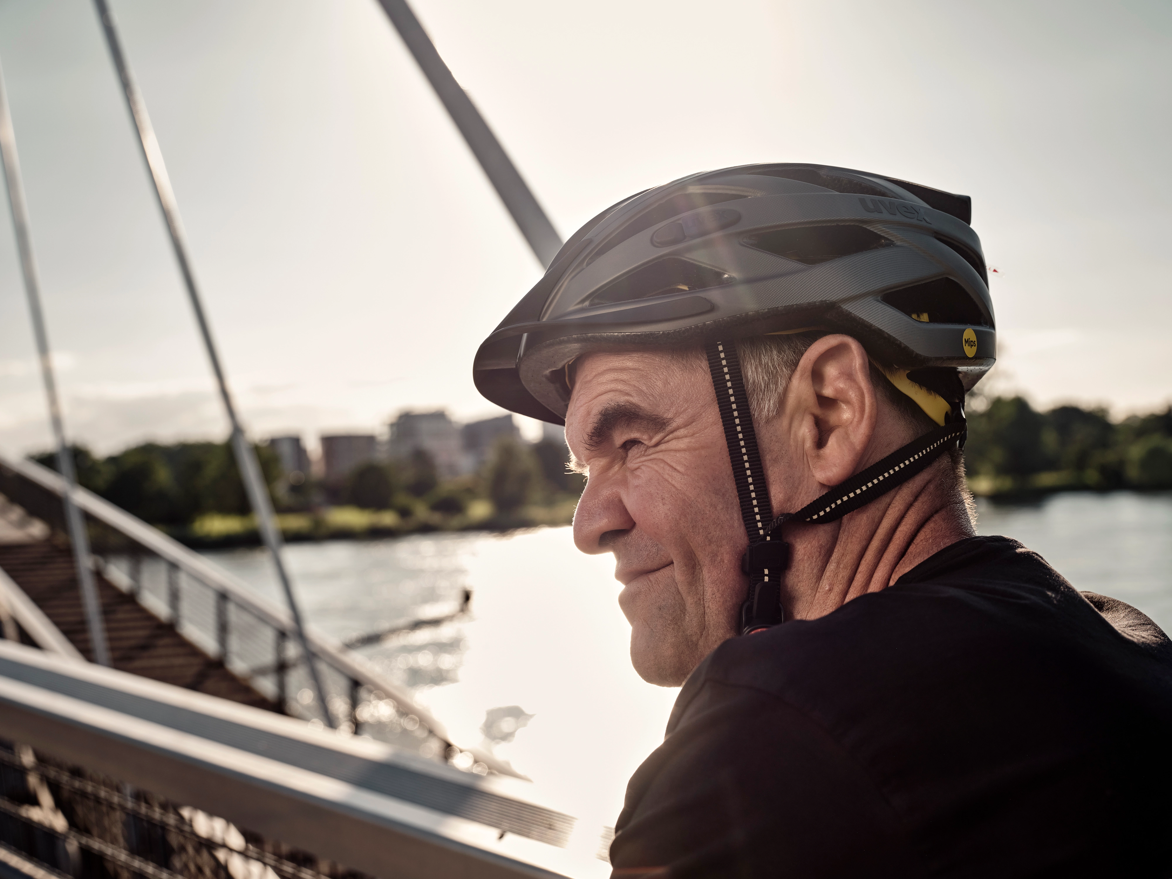 JobRadler auf Fahrradbrücke fährt grinsend in den Feierabend